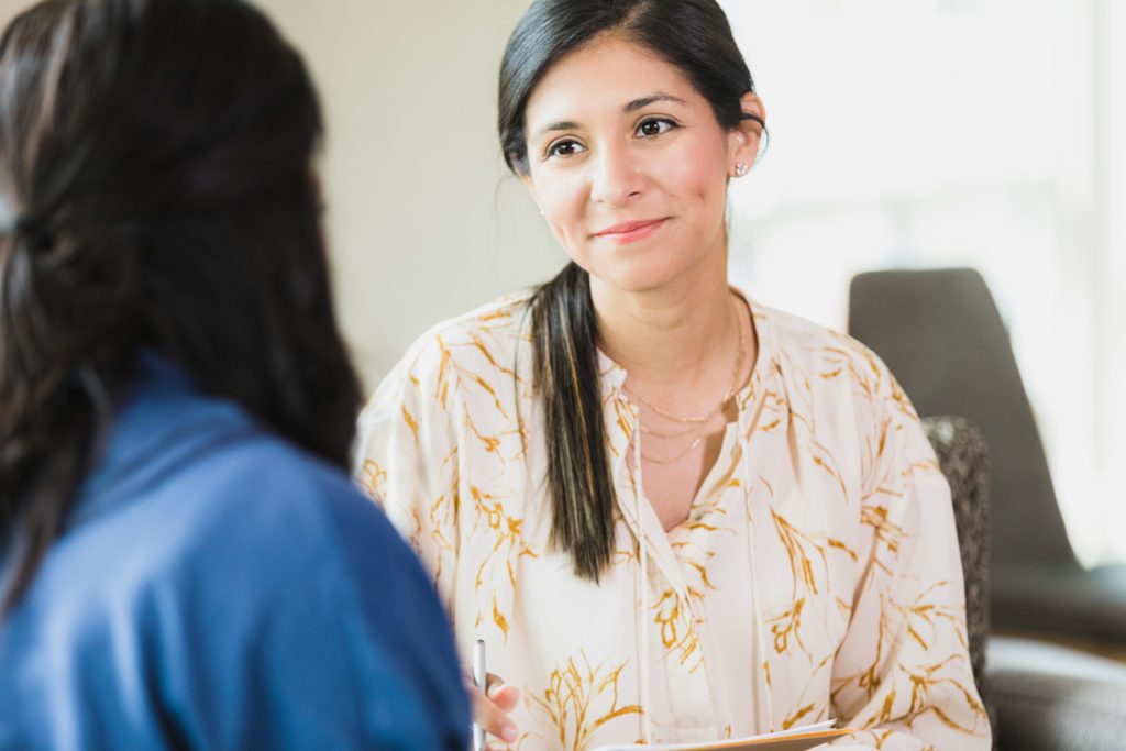 Compassionate female therapist listens to unrecognizable female